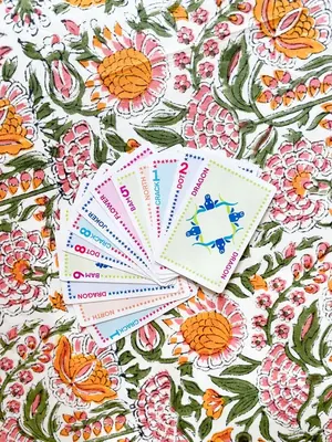 A fan of Classic Edition cards laid on a pink and marigold floral tablecloth