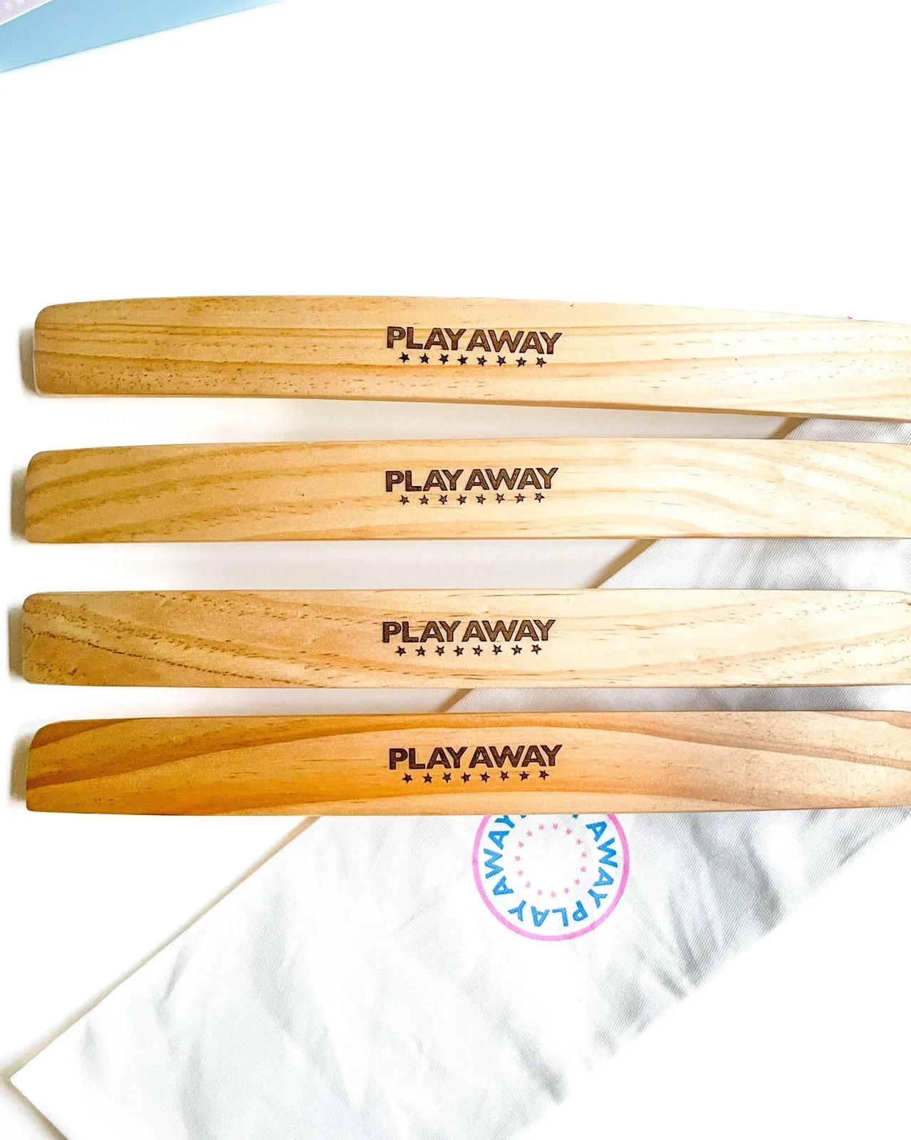 Four wooden Play Away card racks stacked on a canvas drawstring bag