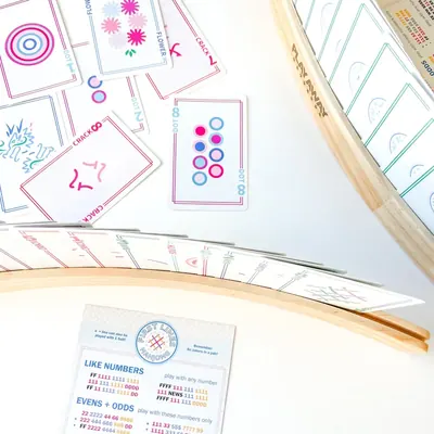 Overhead of Modern Edition cards in two wooden racks with a First Lines card on white